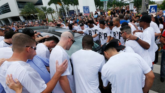 Miami Marlins players and staff surround a hearse carrying the body of pitcher Jose Fernandez as it leaves Marlins Park on Wednesday.