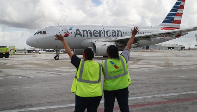 Workers wave as American Airlines Flight 903 prepares for take off, when it became the first commercial flight from Miami to Cuba in 55-years on Sept. 7, 2016.