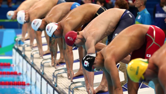 Swimmers wait in the starting blocks during the men's 50-meter freestyle heats in the Rio 2016 Summer Olympic Games at Olympic Aquatics Stadium.