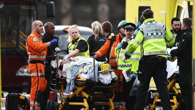 A member of the public is treated by emergency services near Westminster Bridge and the Houses of Parliament in London.