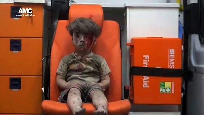 An image grab taken from a video uploaded by the Syrian opposition's activist group Aleppo Media Centre (AMC) on Aug. 17, 2016 is said to show a young Syrian boy covered in dust and blood in an ambulance after being rescued from the rubble of a building hit by an air strike in the rebel-held Qaterji neighborhood of the northern Syrian city of Aleppo.