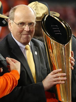 CFP executive director Bill Hancock presents the trophy to Clemson Tigers head coach Dabo Swinney after defeating Alabama Crimson Tide 35-31 in the 2017 College Football Playoff National Championship Game at Raymond James Stadium.