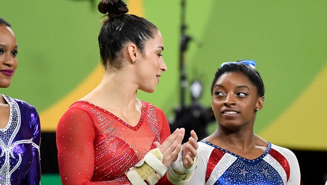 Simone Biles (USA) and Alexandra Raisman (USA) are introduced before the women's individual all-around final in the Rio 2016 Summer Olympic Games at Rio Olympic Arena.