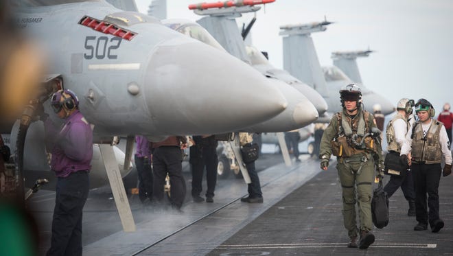 Hornet pilots walk on deck after landing on the USS Eisenhower.