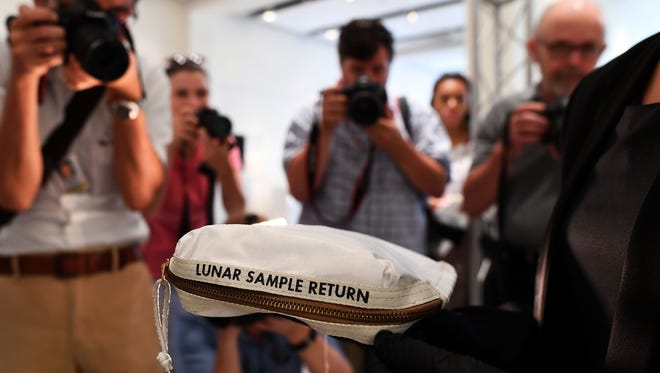 This file photo from July 13 shows Sothebys Cassandra Hatton as she displays the Apollo 11 Contingency Lunar Sample Return Bag, used by Neil Armstrong on Apollo 11 to bring back the very first pieces of the moon ever collected, during a media preview for Space Exploration auction in New York.