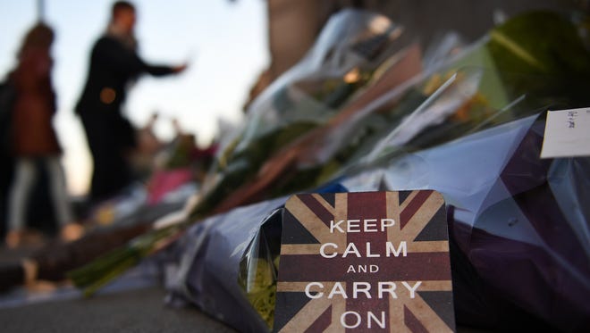 An encouraging message is placed among flowers on Westminster Bridge in London, Friday.