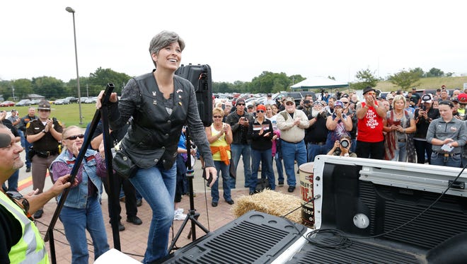 Sen. Joni Ernst climbs into the bed of a truck Saturday, Aug. 27, 2016, to speak to participants before heading out on the second annual Roast and Ride in Des Moines.