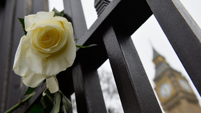A single white rose hangs off the gates of The Houses of Parliament, Friday, after the terror incidents on March 22.