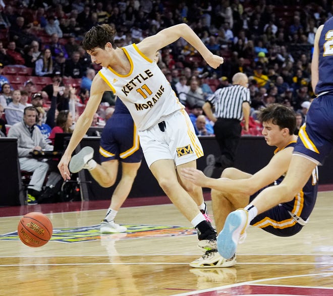 Kettle Moraine's Nathan Vuillaume (11) drives the ball pass Marquette's T.J. Adams (20) during the second half of the WIAA Division 1 boys basketball state semifinal game on Friday March 15, 2024 at the Kohl Center in Madison, Wis.